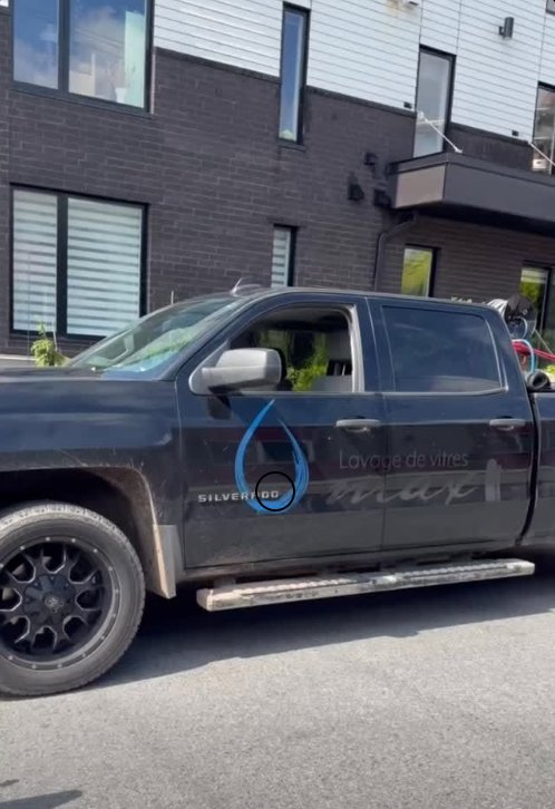 Camion lettré Lavage de vitres OMAX stationné devant une copropriété
